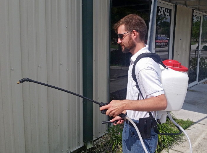 technician spraying house for pests